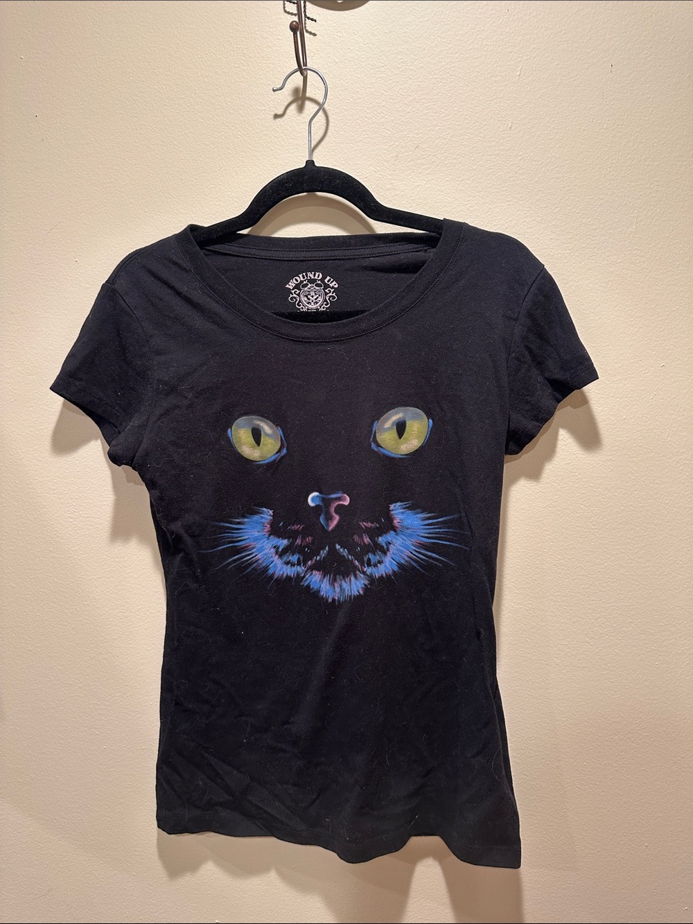 Wound Up Black Tee with Yellow-Eyed Cat Face and Blue Accents